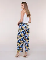 Pantalón estampado de caída fluida y calce relajado, con cintura alta elastizada y cordón ajustable. Presenta una pierna de corte ancho tipo cropped.