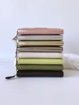 Billetera grande de cuero color negro, con cierre metálico y monedero interno.