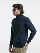 Polera de tejido de punto fino en color verde oliva, con cuello alto acanalado y mangas largas.