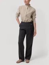 Pantalón de tiro alto y corte recto color gris, confeccionado con mezcla de lana y poliéster reciclado. Cuenta con pretina limpia, botón lateral decorativo y cierre invisible.