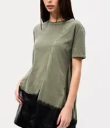 Remera verde militar de algodón con efecto desteñido, cuello redondo, mangas cortas, recortes asimétricos y detalle de encaje negro en el bajo irregular.