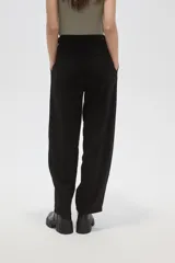 Pantalon de vestir de corte barrel y tiro alto, color negro, con cierre frontal y bolsillos laterales.