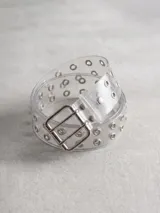 Cinturón de material plástico transparente con diseño de doble ojal metálico a lo largo de toda la tira y hebilla metálica de doble marco.