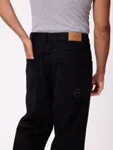 Jean de corte slouchy en color negro, confeccionado en algodón, con diseño de tiro medio y ajuste holgado en las piernas.