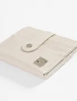 Tarjetero de cuero vegano con acabado brillante, cierre con solapa y broche a presión. Cuenta con ranuras para tarjetas y detalle de logo metálico en la parte frontal.