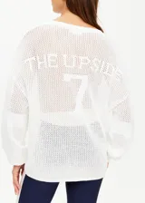 Buzo de punto abierto semitransparente, color blanco, con cuello redondo, mangas largas con hombros caídos y logo tejido en la espalda.