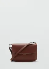 Bolso de hombro tipo bandolera en color marrón, con diseño estructurado de solapa, cierre metálico a presión y costuras decorativas en contraste. Incluye correa larga ajustable.