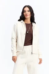 Campera tipo hoodie de algodón en color gris oscuro, con cierre frontal completo, capucha con cordones ajustables y bolsillos laterales. Presenta un diseño minimalista con logo bordado sutil en el pecho.