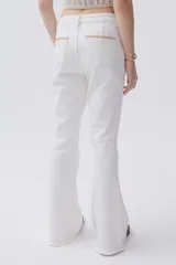 Jean blanco de tiro medio-alto y pierna acampanada estilo Oxford, con pespuntes en zigzag en los bolsillos traseros y terminación desflecada.