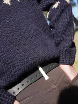 Cinturón unisex de cuero negro con perforaciones a lo largo para ajuste y hebilla metálica.