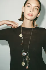 Cinturón tipo cordón con eslabones metálicos dorados y colgantes de charms con piezas de resina de colores. Cierre con mosquetón.