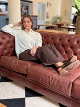 Zueco de cuero color chocolate con diseño cerrado en la parte frontal y suela de goma con plataforma baja.