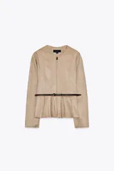 Chaqueta color beige con efecto ante, cuello redondo, manga larga y cierre frontal con cremallera. Presenta un bajo en evasé y un cinturón fino de cuero marrón oscuro con hebilla metálica.