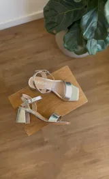 Sandalias de taco cuadrado bajo en color plateado, con diseño de punta cuadrada y tira ajustable con hebilla en el tobillo.