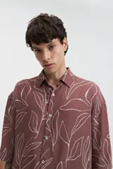 Camisa oversize de manga corta con cuello clásico y estampado abstracto en tonos grises.