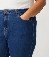 Pantalón mom jeans azul oscuro, tiro alto, con bolsillos delanteros y traseros, trabillas en la cintura, cierre frontal con botón y cremallera, y dobladillo doblado.