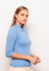 Polera manga 3/4 color lila, de corte ajustado y cuello alto con detalle de tela con textura a rayas horizontales.