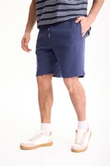 Bermuda deportiva sin friza color azul marino, con cintura elástica con cordón ajustable y bolsillos laterales.