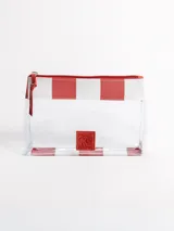 Bolso tipo tote grande, resistente al agua, con diseño de rayas verticales rojas y blancas. Cuenta con asas largas de hombro, cierre superior y parche de cuero con logo grabado. Incluye neceser transparente a juego con base y detalles a rayas.