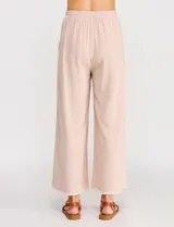 Pantalón palazzo de lino color beige, de tiro alto y silueta suelta, con cintura elastizada y cordón de ajuste. Cuenta con detalles de ribetes bordados festoneados en contraste en los bolsillos y en el ruedo.