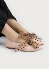Bailarina de piel natural color rosa pálido, con detalle de lazo de tul transparente con lunares negros y ojales metálicos plateados en los laterales.