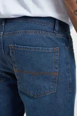 Pantalón de jean azul oscuro, corte recto, tiro medio y cinco bolsillos.