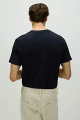 Remera de hombre color azul marino, de corte recto y manga corta. Confeccionada en tejido funcional COOLMAX, una fibra de poliéster de secado rápido que elimina la humedad y regula la temperatura corporal.