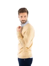 Sweater de punto con escote en V y mangas largas, confeccionado en una mezcla de algodón, nylon y spandex. Presenta un diseño clásico de corte recto con puños y ruedo acanalados.