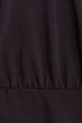 Vestido corto de punto fino en color negro, con escote bote, costura fruncida en la cintura y mangas capa largas con diseño abultado.