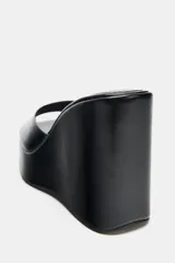 Sandalias de tacón tipo cuña alta con diseño estilo mule, color negro, con tira delantera ancha y puntera cuadrada.