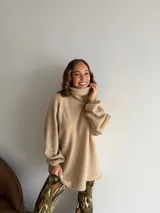 Poleron de cuello alto en color beige, con diseño holgado y mangas largas con puños elásticos.