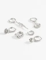 Set de aros plateados con diferentes dijes: argollas con concha de mar, argolla con cocodrilo, argolla con concha de abanico, argolla trenzada, argolla con piedra.