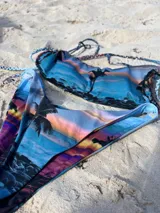 Bikini semivedetina en V con estampado de palmeras y atardecer.