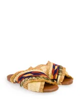Sandalia plana con tiras cruzadas de rafia color beige, con aplicaciones de mostacillas de colores y monedas doradas.