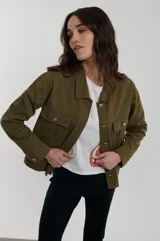 Campera de estilo utility con cuello camisero, cierre frontal de botones dorados y bolsillos de parche con solapa en el pecho.