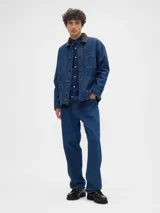 Campera de jean color azul oscuro, con cuello de pana en tono marrón, cierre frontal con botones metálicos y tres bolsillos frontales tipo parche.