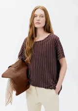 Blusa de manga corta con diseño a rayas verticales en color bordó y blanco, de corte holgado y cuello redondo.