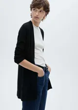 Cardigan de punto fino color negro, con cuello en pico, diseño recto y manga larga. Es una prenda abierta sin cierre, ideal para usar como capa ligera.