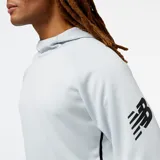 Buzo deportivo New Balance Tenacity Hoodie color celeste, con capucha, bolsillo tipo canguro y logo de la marca en la manga.