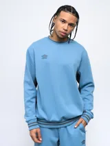 Buzo negro de corte clásico con cuello redondo, puños y ruedo acanalados con doble línea blanca. Logo de Umbro bordado en el pecho. Mangas con paneles laterales en gris. Confeccionado en algodón y poliéster.