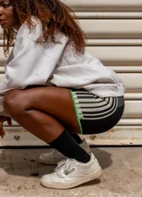 Short deportivo color crema con cintura elástica y rayas verticales marrones en los laterales.