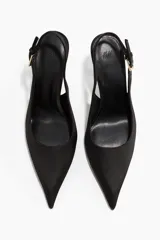 Zapatos de tacón tipo slingback con punta fina, confeccionados en satén negro. Presentan una tira ajustable en el talón con hebilla metálica lateral y tacón fino.