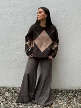 Sweater de punto con diseño de rombos en tonos marrón y beige, de corte holgado y cuello redondo.