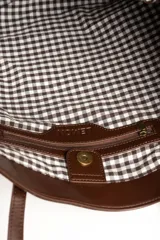 Bolso tipo shopper color marrón de cuero sintético con diseño trenzado. Cuenta con doble asa de hombro y placa metálica con el logo de la marca en el frente.