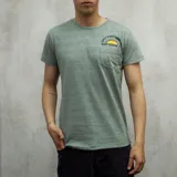 Remera verde jaspeado de algodón con cuello redondo y manga corta. Estampa en el pecho con un sol naciente y la frase "Only Good Vibes Surf Duxon Co.". Incluye bolsillo pequeño en el pecho.