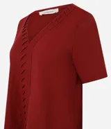 Blusa verde militar de piqué, corte slim, con escote en V y detalle texturizado en la vista delantera. Tiene mangas cortas.