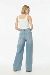 Pantalón jean celeste de tiro medio y corte ancho, con presillas, bolsillos delanteros y traseros, e incluye un cinturón largo del mismo material con hebilla metálica.