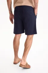 Bermuda de gabardina con spandex, cintura elastizada y cordón ajustable, de corte recto y color azul marino.