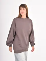 Buzo de cuello redondo en color gris oscuro, con corte holgado y mangas largas con puños elásticos. Presenta un pequeño bordado en el pecho con la palabra 'Cupid' y un corazón.