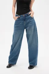 Pantalon jean de corte barrel y tiro medio, en color negro, con diseño de pierna ancha y estructura rígida.